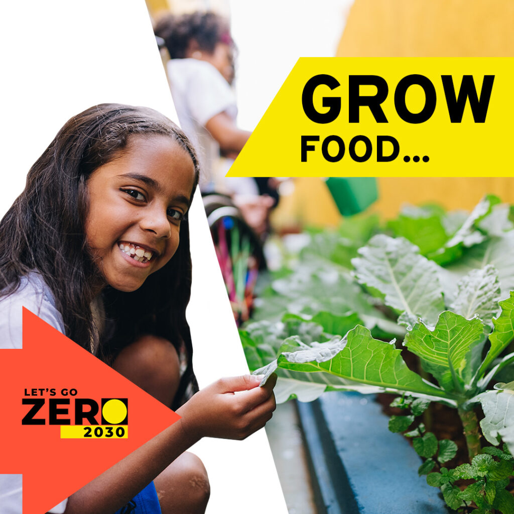Text reads: Grow food. A school pupil is smilling at the camera whilst crouched down next to a cabbage that they have grown.