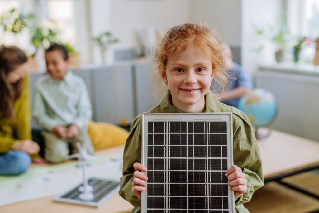 Little girl holding a solar panel