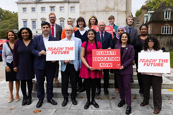 A group of councillors, local MPs and supporters of Teach the future are stood together in solidarity holding up banners.